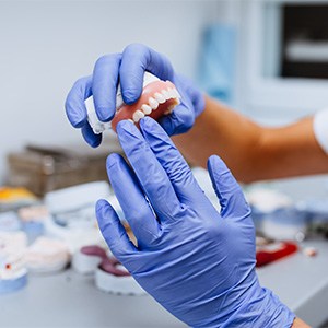 A dental lab technician crafting dentures