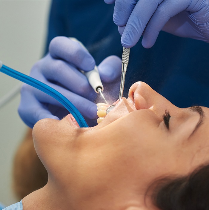 Dental hygienist cleaning patient's teeth