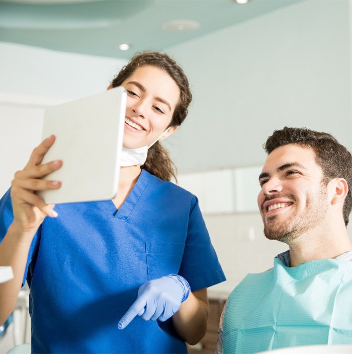 Dentist showing patient image on tablet