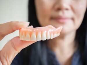 closeup of a woman holding a denture